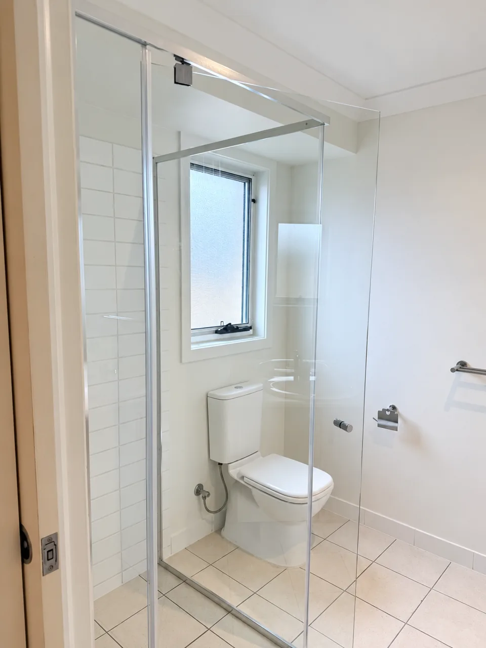 Glass shower and tiled bathroom after cleaning